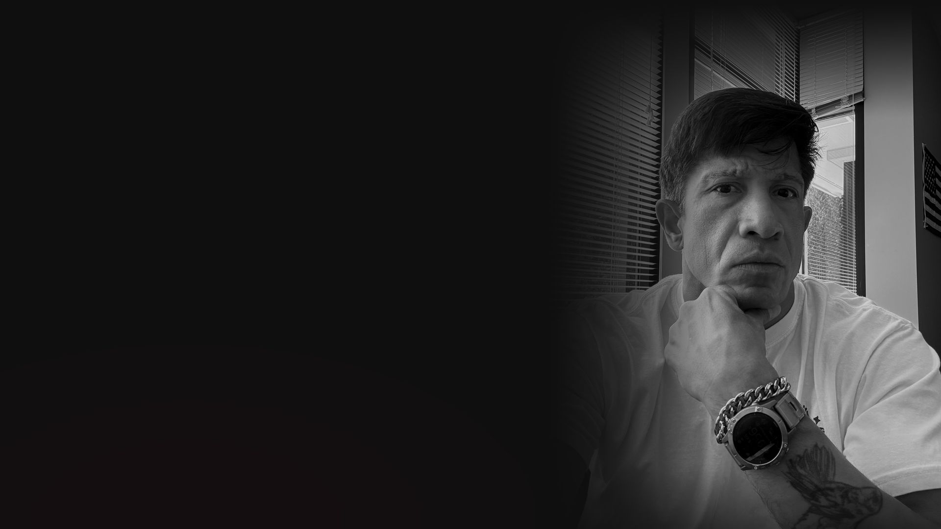 Black and white portrait of Michael Schatz, hand on chin, blended into a dark background